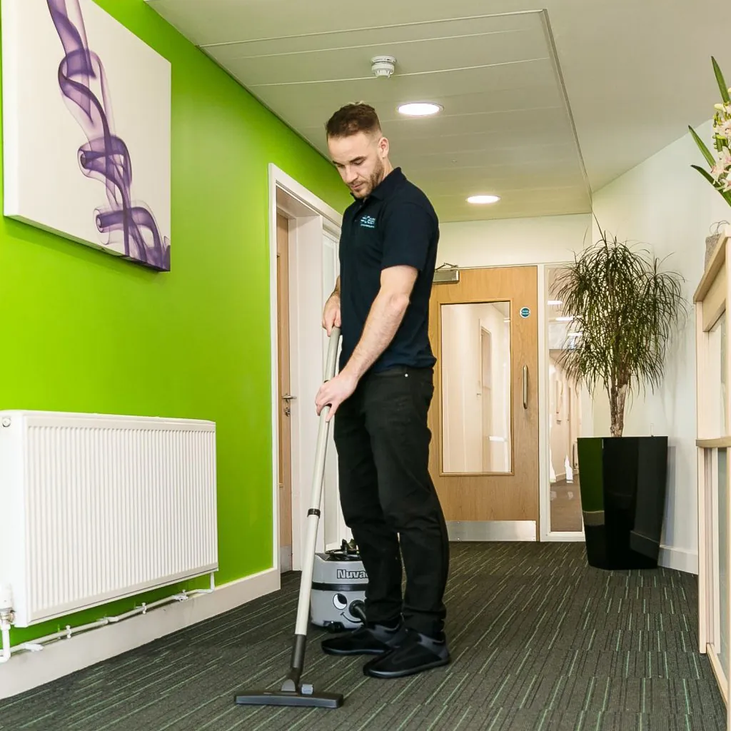 Brighton office cleaner vacuuming a carpet in Sussex