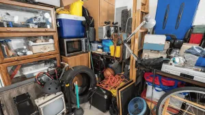 Overfilled room with tangled cords, household clutter, and mixed waste requiring hoarder cleaning