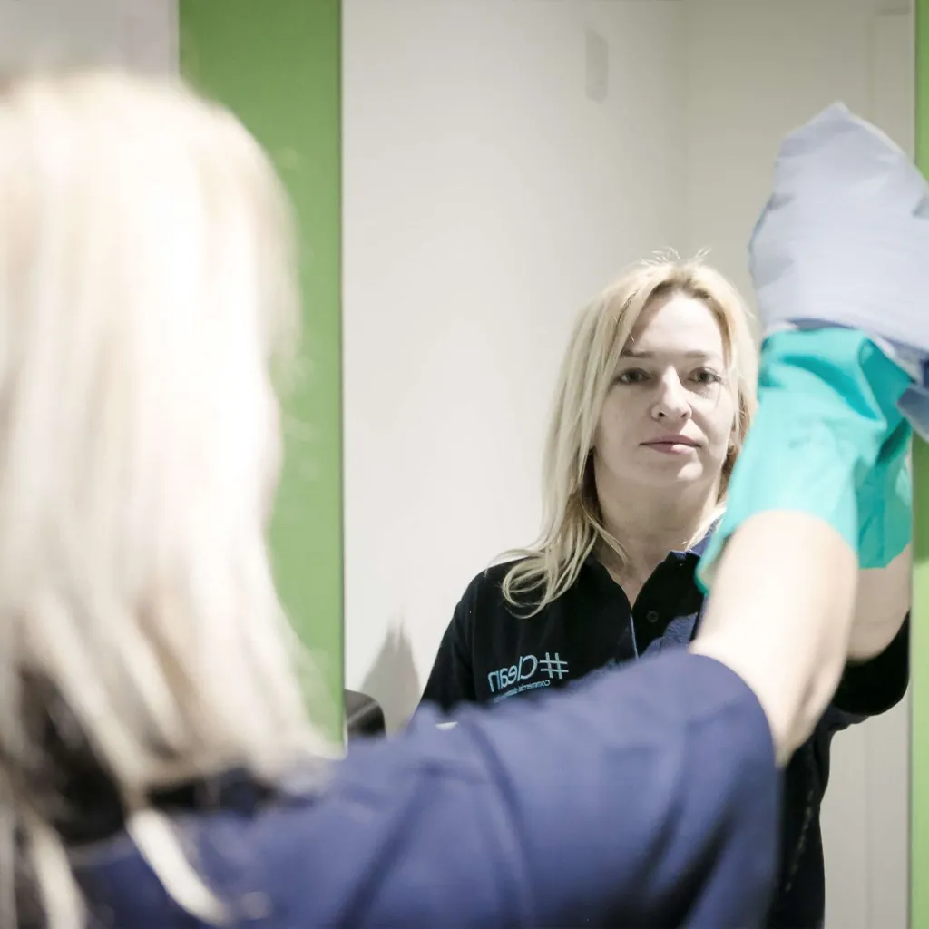 Brighton office cleaner wiping a mirror in Sussex