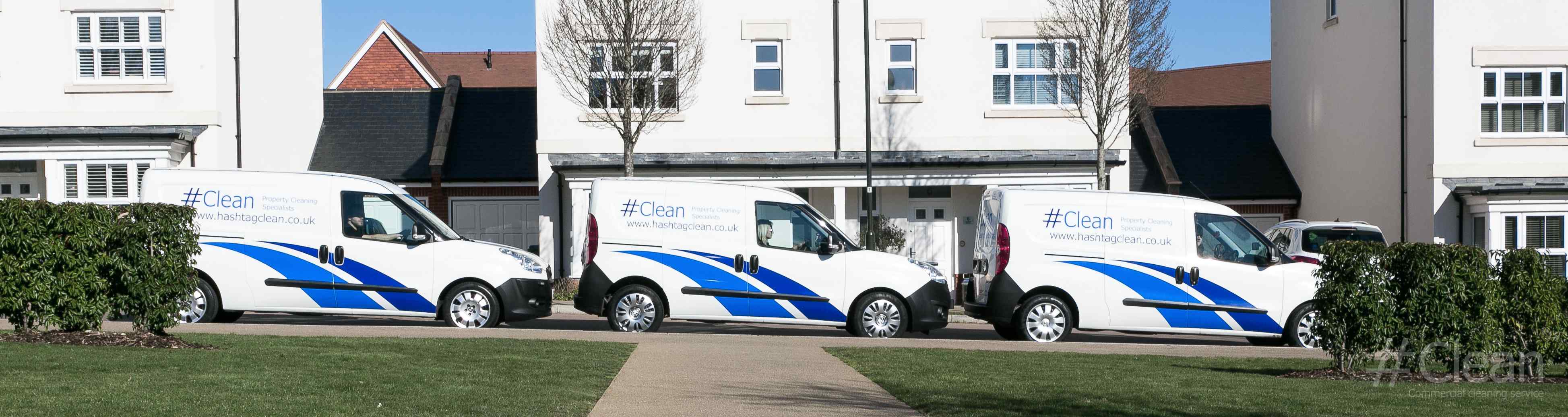 Three Hashtag Clean Vans Parked In A Housing Estate