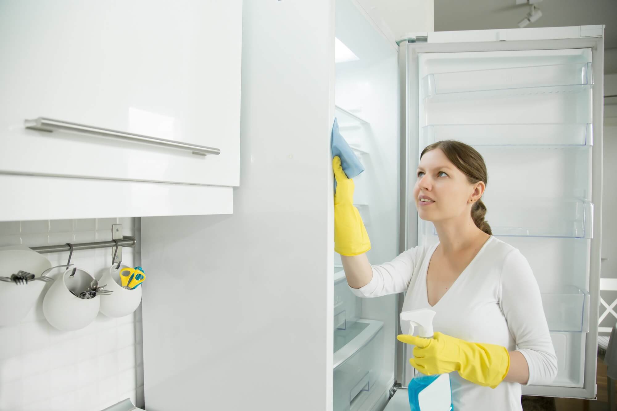 Young Woman Wearing Rubber Gloves Cleaning The Fridge 1
