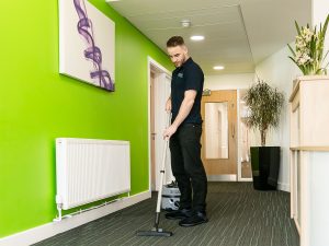 Cleaner vacuuming office carpets during a commercial end of tenancy cleaning service