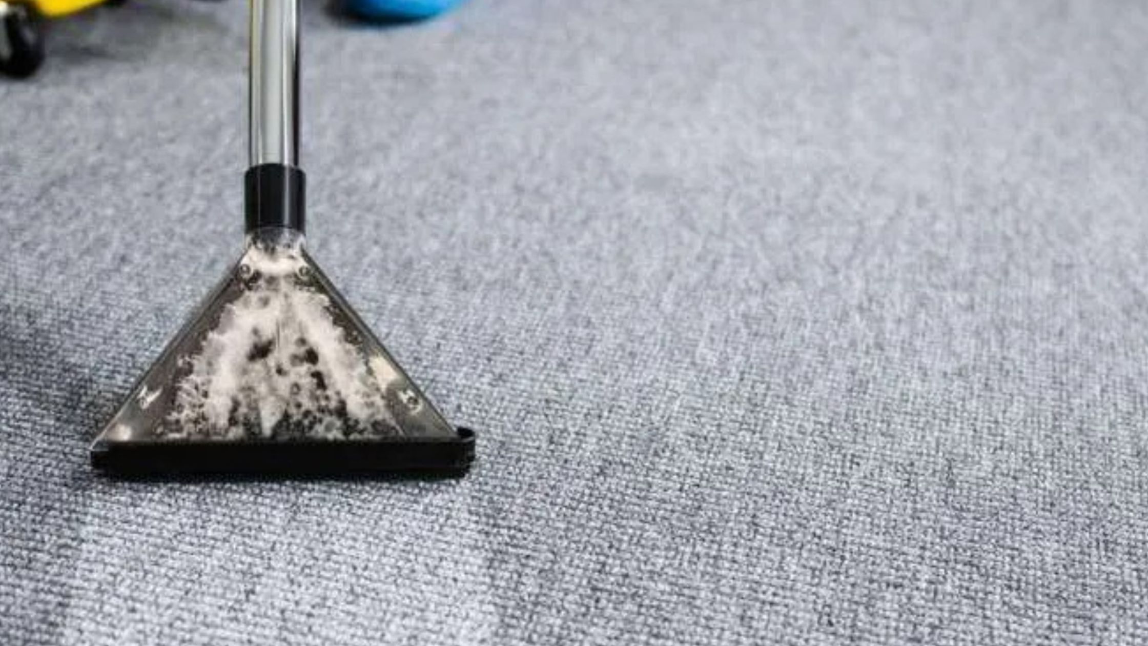 Professional carpet cleaning machine deep cleaning a grey commercial carpet during a spring commercial clean