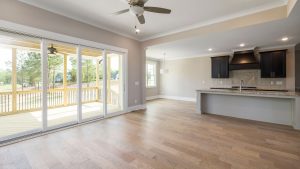 A clean and bright open plan living space featuring a modern kitchen area and sliding doors to an outdoor patio.